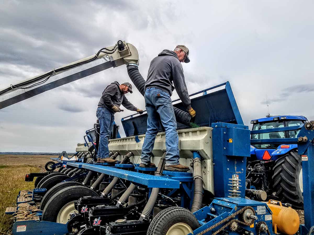 ag producers repairing farm machinery in the field
